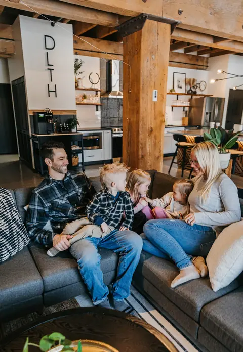 A family relaxing on a sectional in a Brix condo in Canal Park