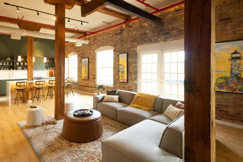 Aerial East living room with exposed brick, Douglas Fir beams and a large sectional
