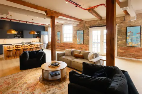 Aerial West living room and kitchen with exposed brick and Douglas Fir beams